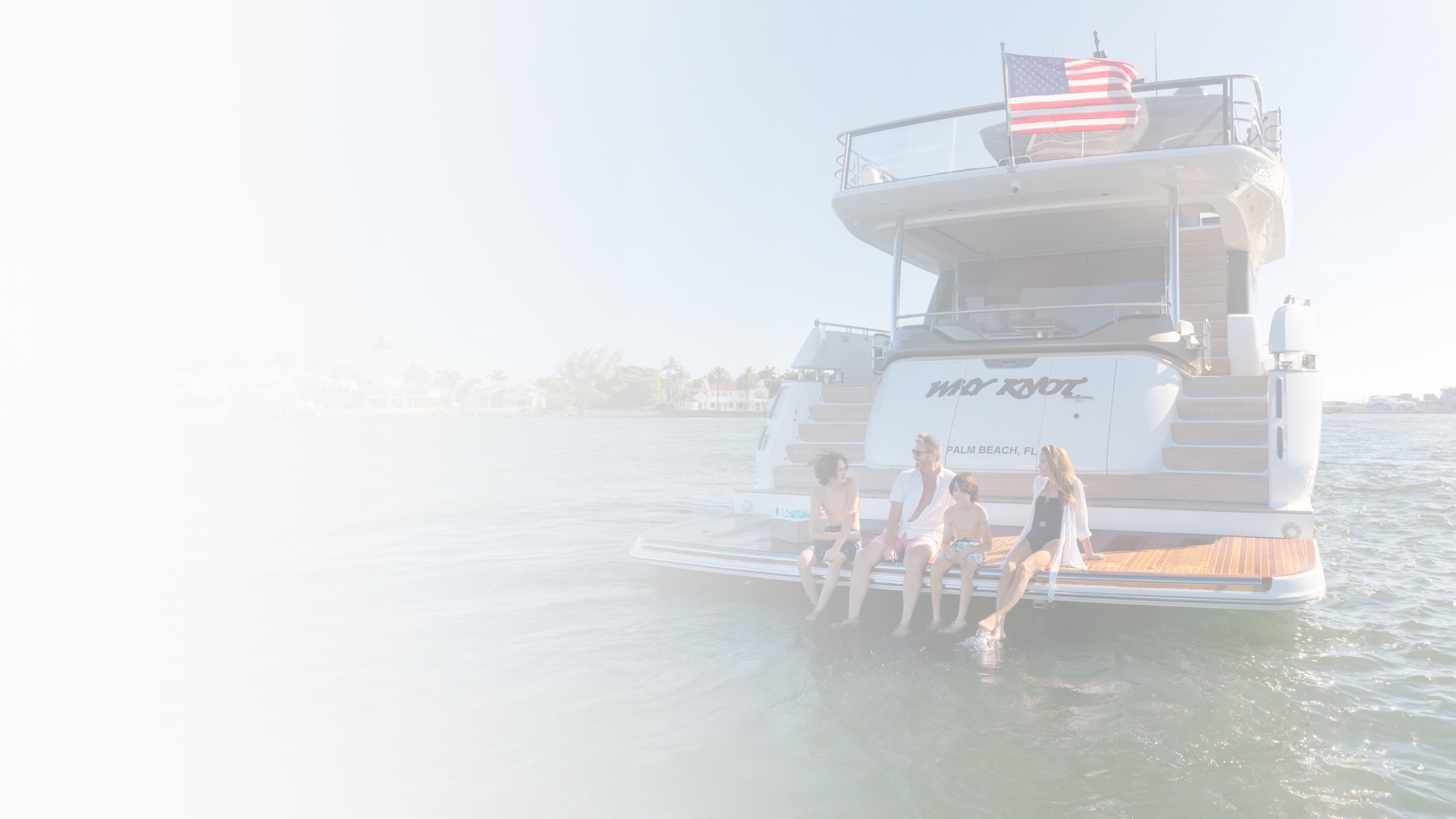 Family sitting on back of yacht